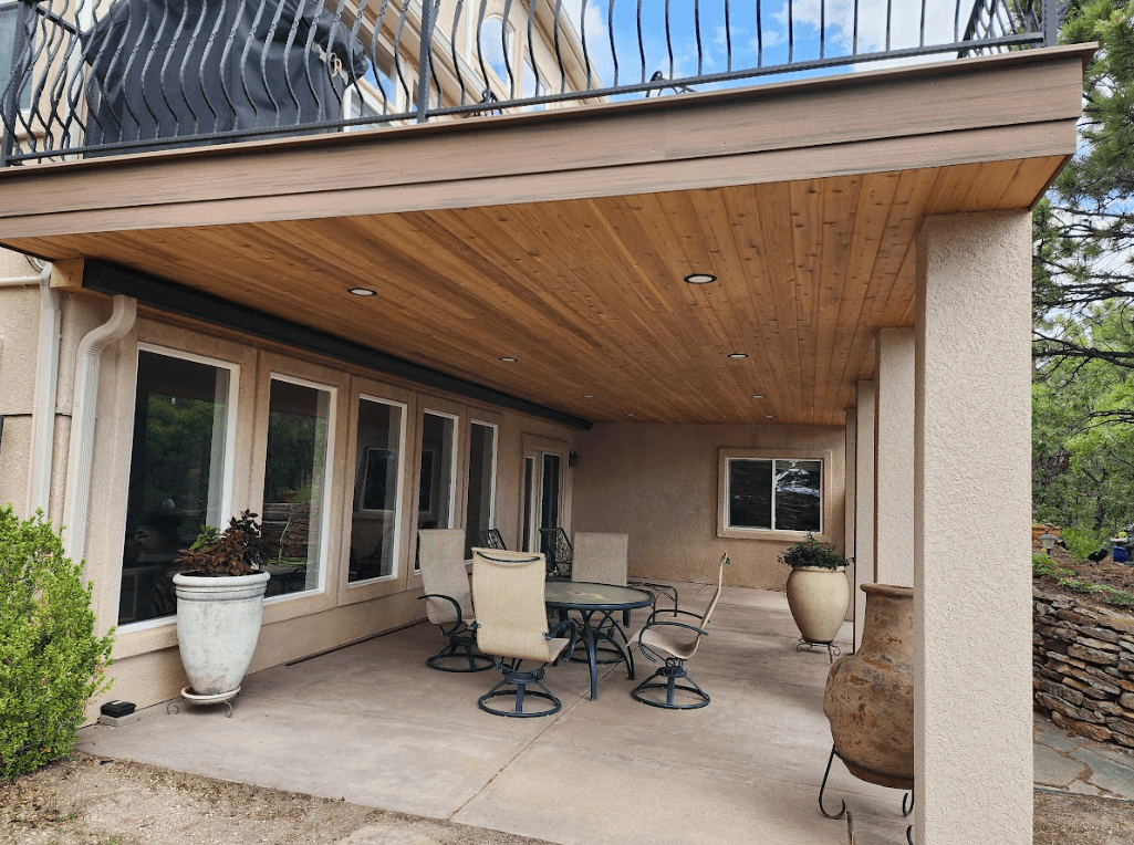 photo of an elevated deck with a finished ceiling below serving as a patio cover - Patio Cover ideas with furniture,