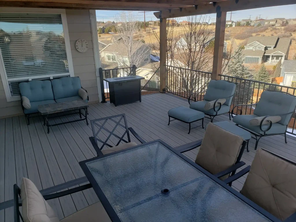 covered deck with outdoor furniture overlooking a housing development