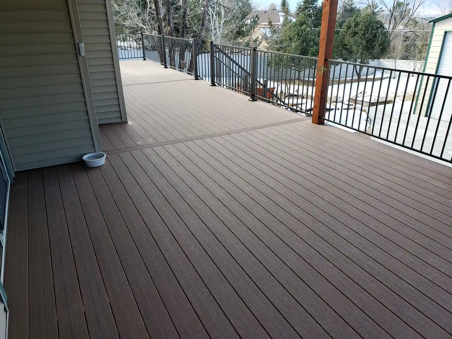 Trex deck with brown planks and black railing in a spacious outdoor area