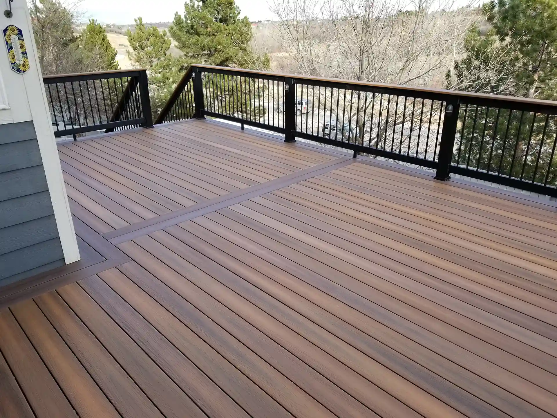 Trex deck with brown planks and black railing in a spacious outdoor area.