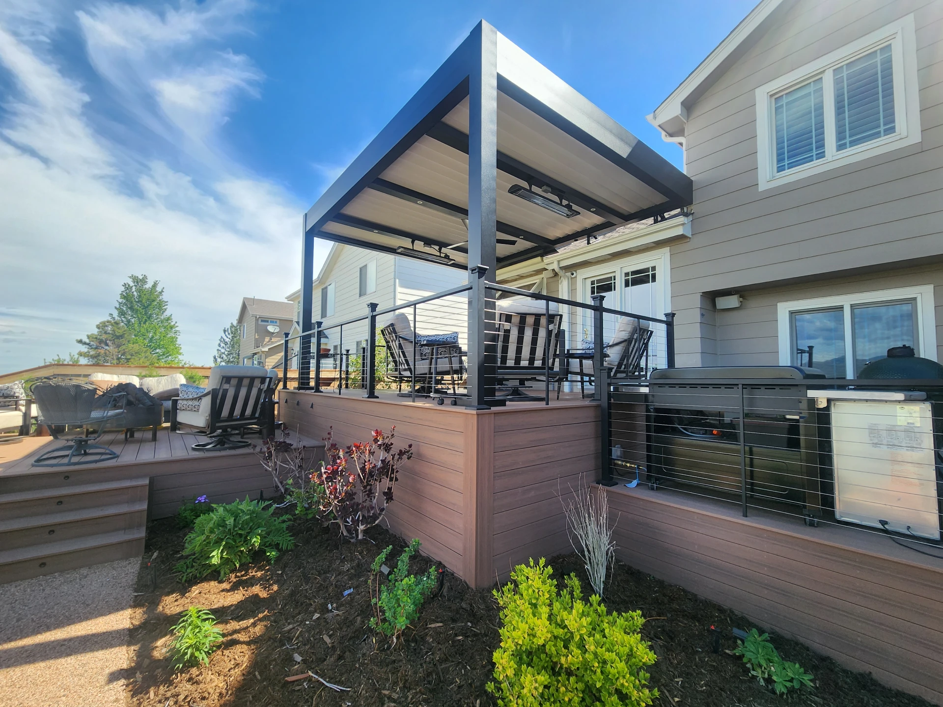 composite-deck-with-skirting-and-cable-railing-with-attached-louvered-pergola-and-outdoor-living-lounge-barbecue-grill-in-castle-rock-co
