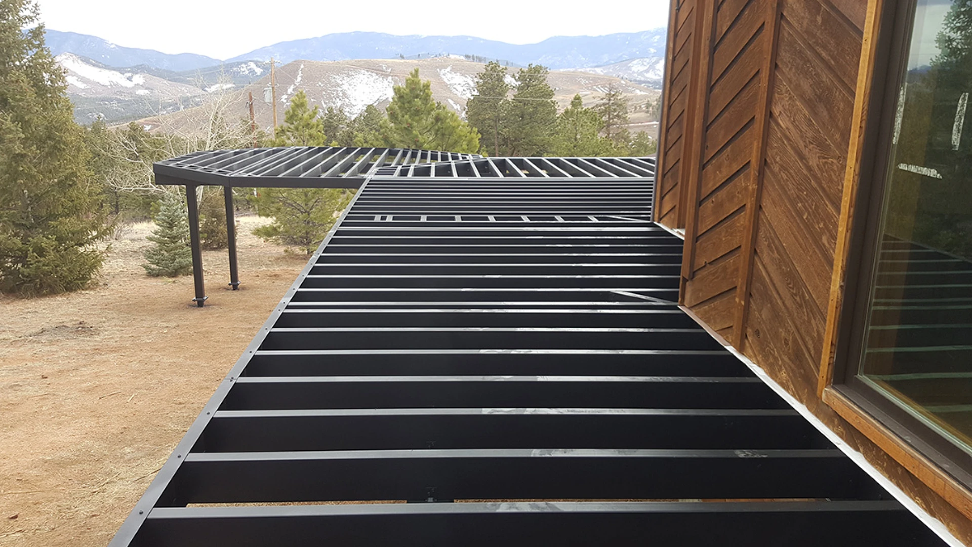 custom-evolution-steel-deck-framing-attached-on-the-brown-house-featuring-mountain-trees-view-in-castle-rock-co