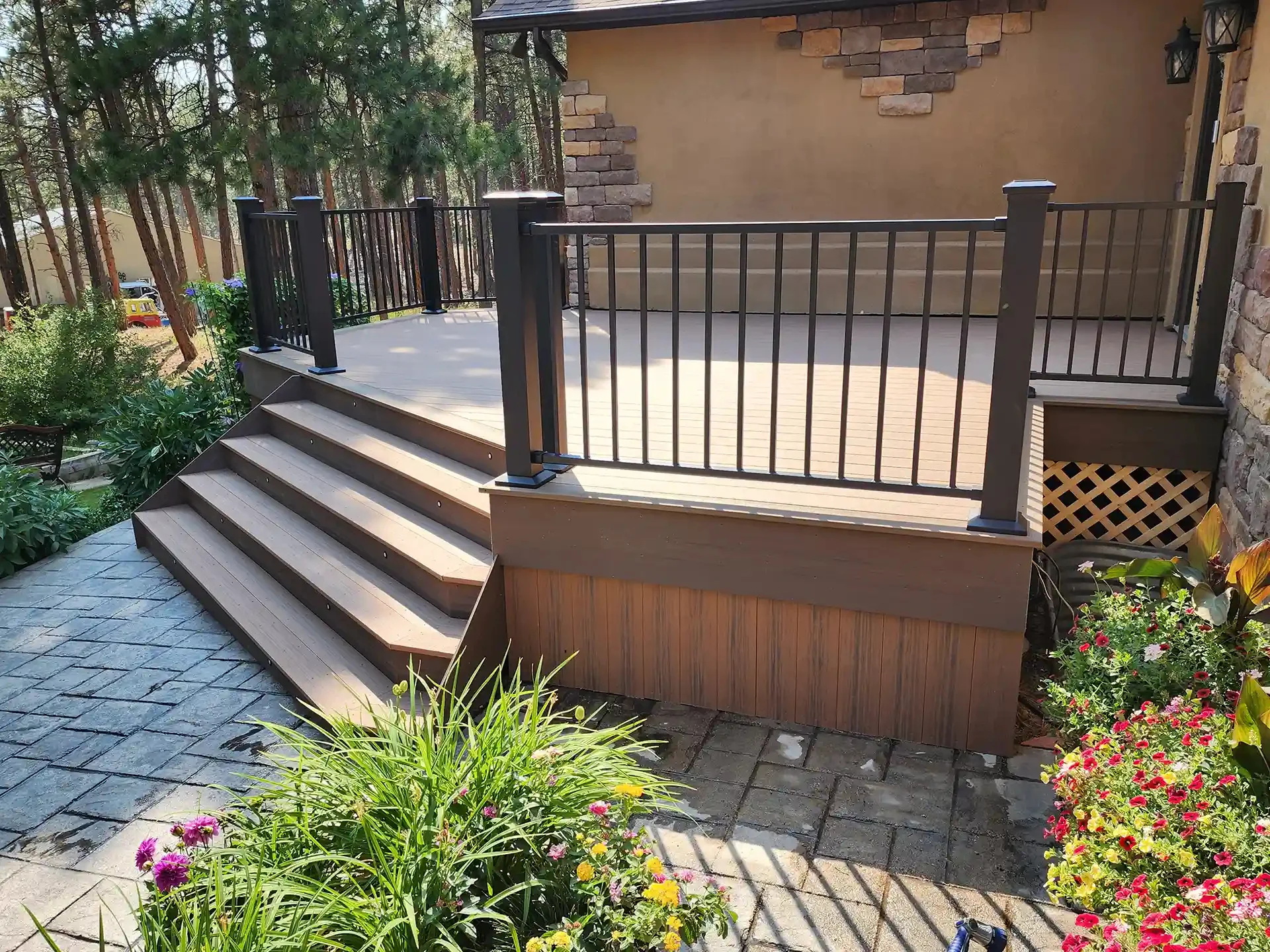 custom-residential-deck-with-black-railings-and-lights-on-steps-with-skirting-featuring-beautiful-plants-in-castle-rock-co
