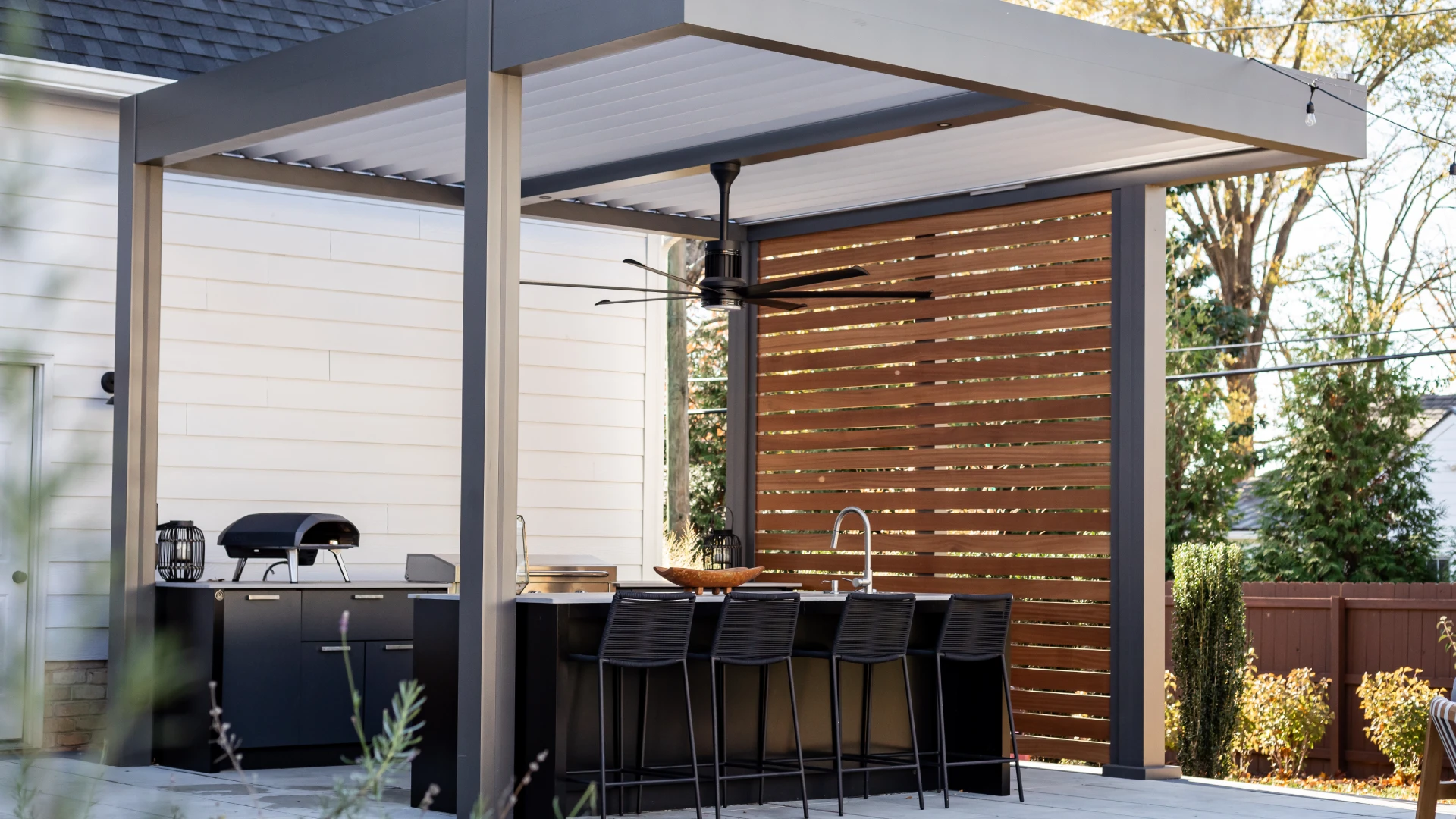 gray-bronze-white-louvered-pergola-with-wooden-privacy-screen-and-outdoor-living-kitchen-in-castle-rock-co