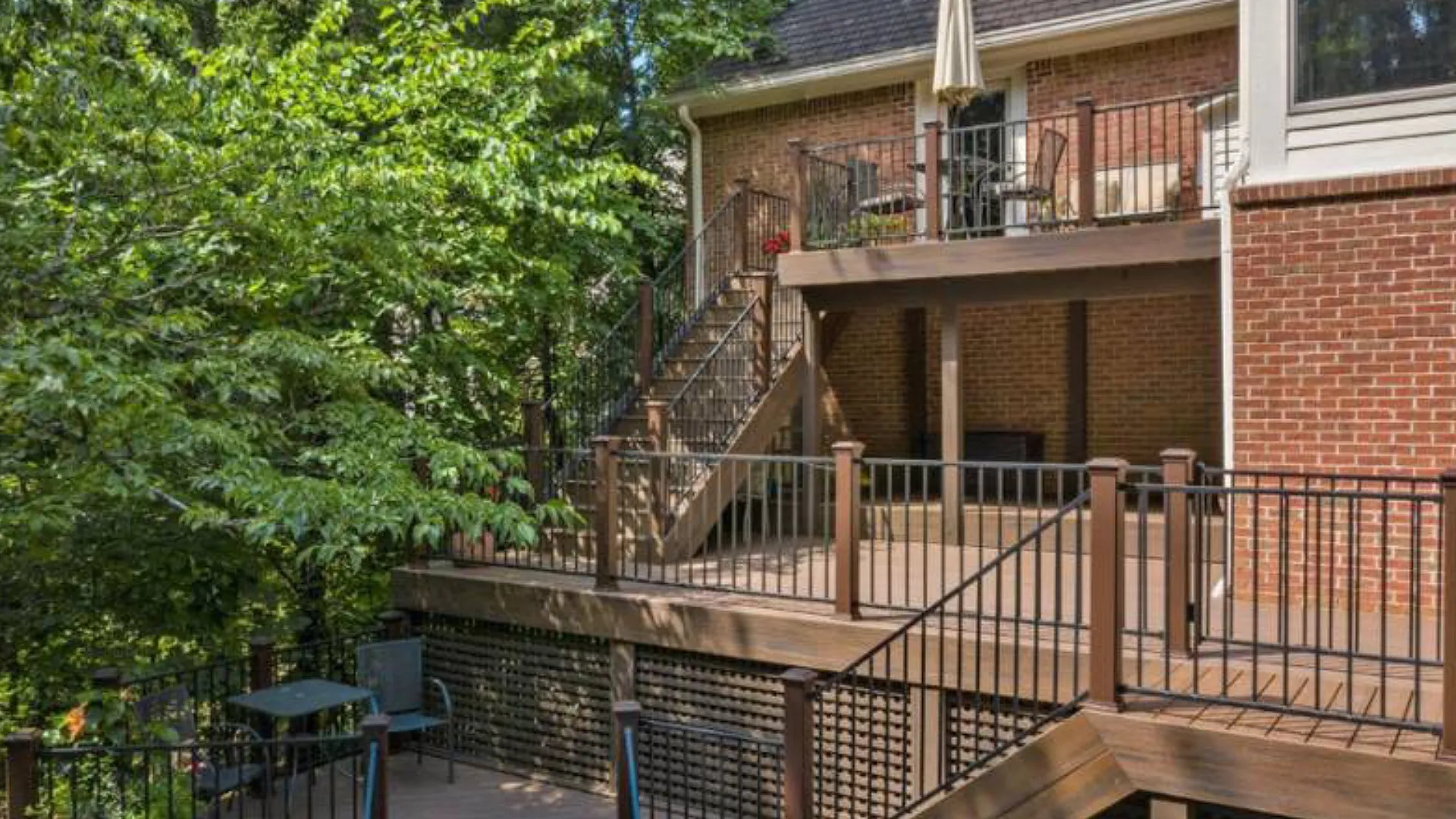 multi-level-custom-deck-with-skirting-and-outdoor-living-space-on-the-brick-house-surrounded-by-trees-on-the-side-of-the-house-in-castle-rock-co