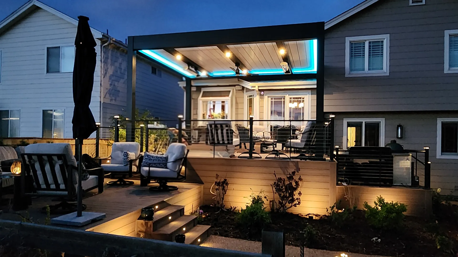 multi-level-pvc-deck-with-skirting-and-lights-on-stairs-step-post-cap-lights-and-outdoor-living-dining-set-area-with-modern-led-louvered-cabana-in-castle-rock-co