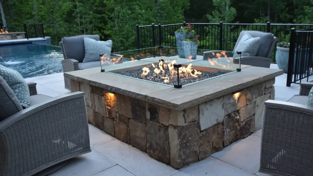 patio-construction-with-outdoor-fire-pit-and-fire-place-with-black-metal-railings-featuring-big-trees-on-the-background-in-castle-rock-co