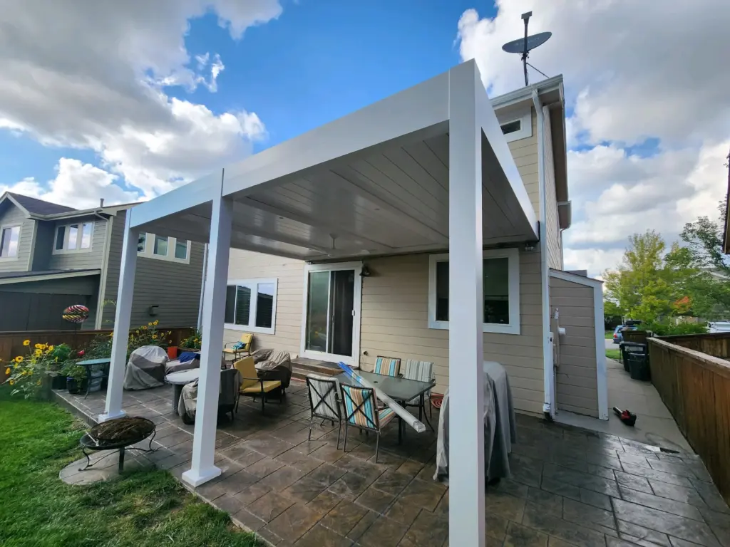 paver-patio-with-attached-pergola-on-the-residential-house-with-decorative-potted-plants-featuring-wooden-wall-fence-and-cloudy-sky-on-the-background-in-castle-rock-co