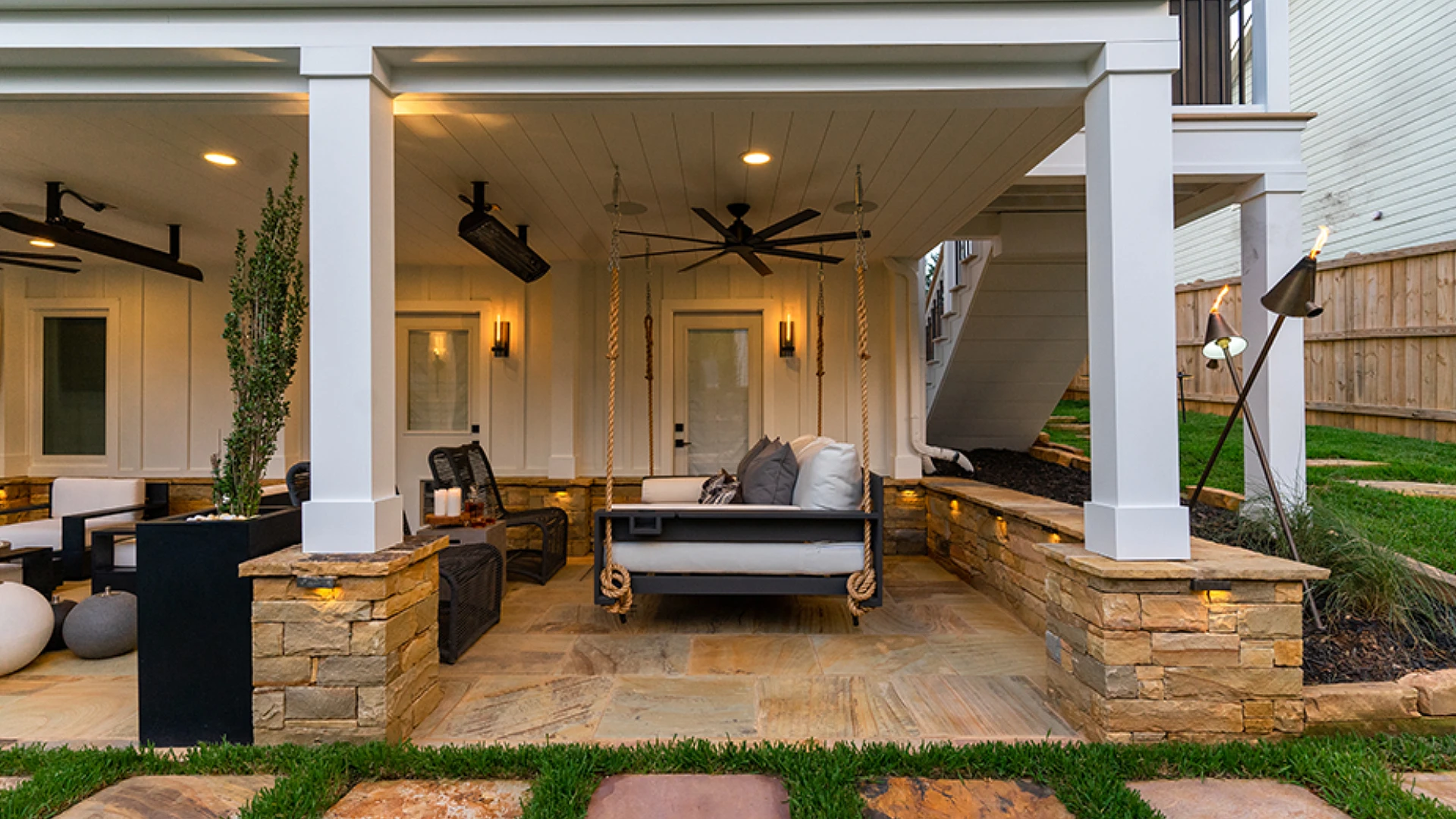 paver-patio-with-outdoor-living-sofa-with-fan-and-lighting-on-the-ceiling-with-wooden-wall-privacy-fence-on-the-side-house-in-castle-rock-co