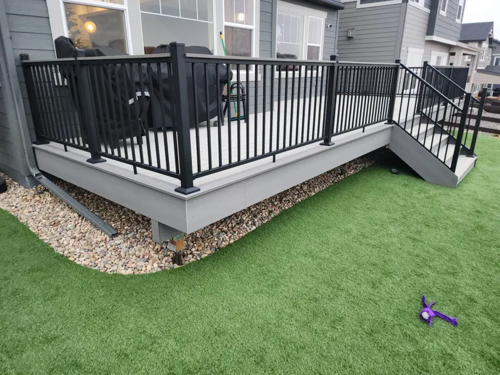 raised-custom-deck-with-black-metal-railings-and-covered-furniture-on-the-gray-residential-house-in-castle-rock-co