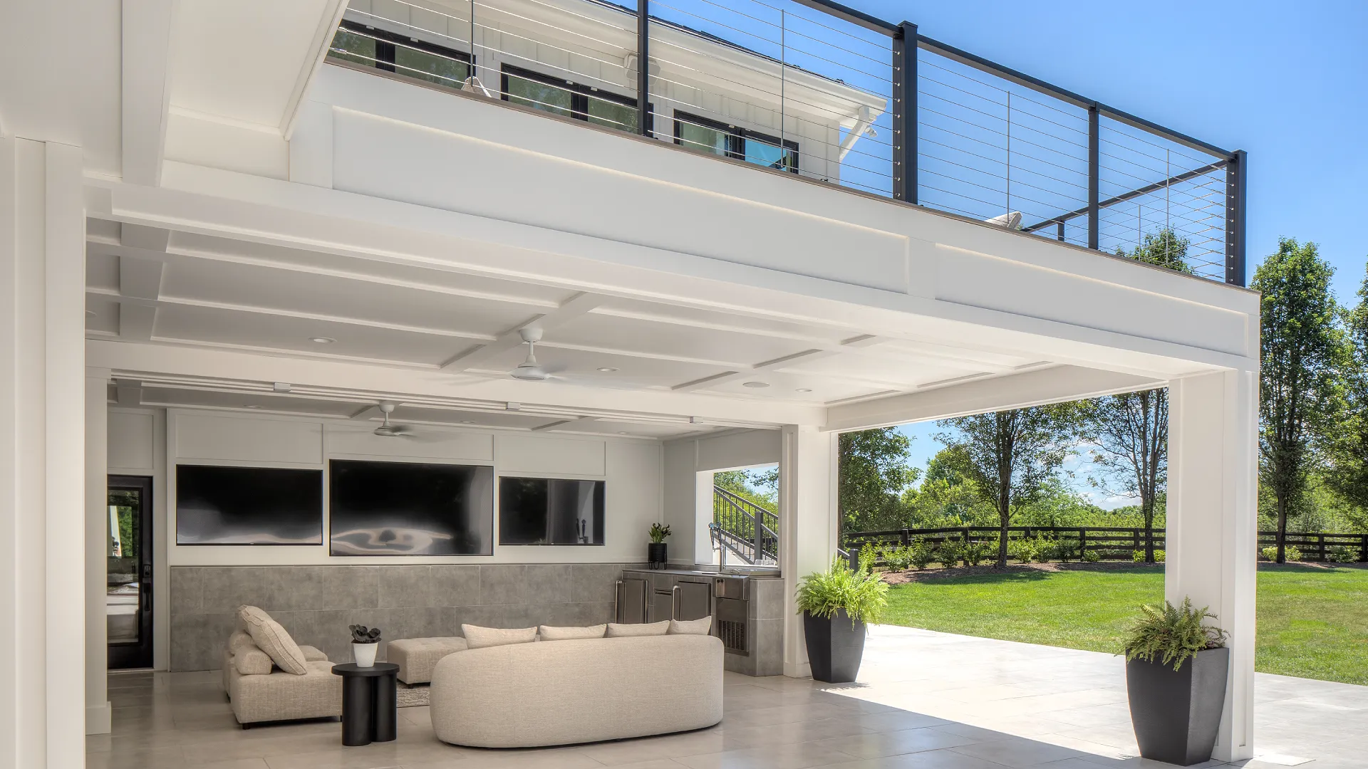 white-under-deck-system-with-outdoor-living-sofa-and-potted-plants-with-tv-on-the-wall-featuring-black-privacy-fence-on-the-backyard-in-castle-rock-co